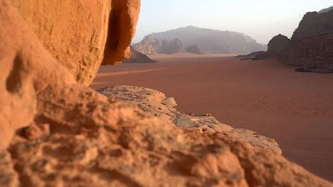 Young man is to the top of cliff. Wadi Rum also known as The Valley Stock Footage 126784539