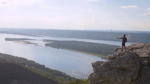 Young man on top of the mountain relieves itself on camera Stock Footage 72587520