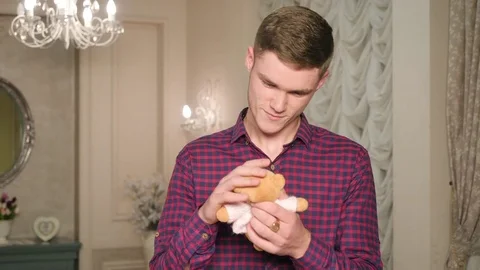 Young man touching and caressing on head cute small teddy bear Stock-Footage 83666260