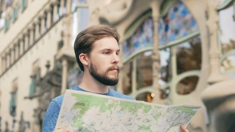 Young man tourist checking map in Barcelona Stock Footage 125699866