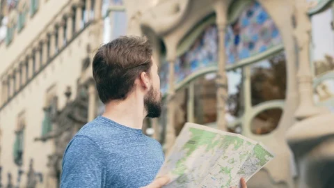 Young man tourist checking map in Barcelona Stock Footage 125700998