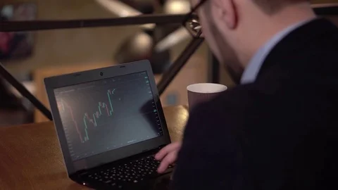 Young man trader with a beard stops to study cryptocurrency market and removes Stock Footage 85438389