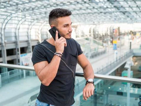 Young man in train station calling on cellphone Stock Photos