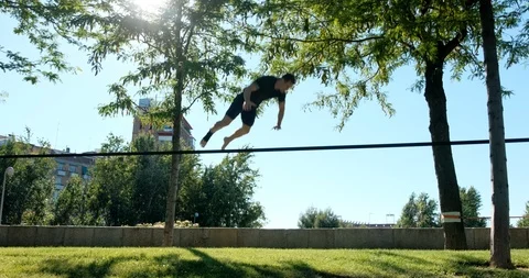 Young Man Training As Acrobat With Trickline In City Park Stock Footage 111231994