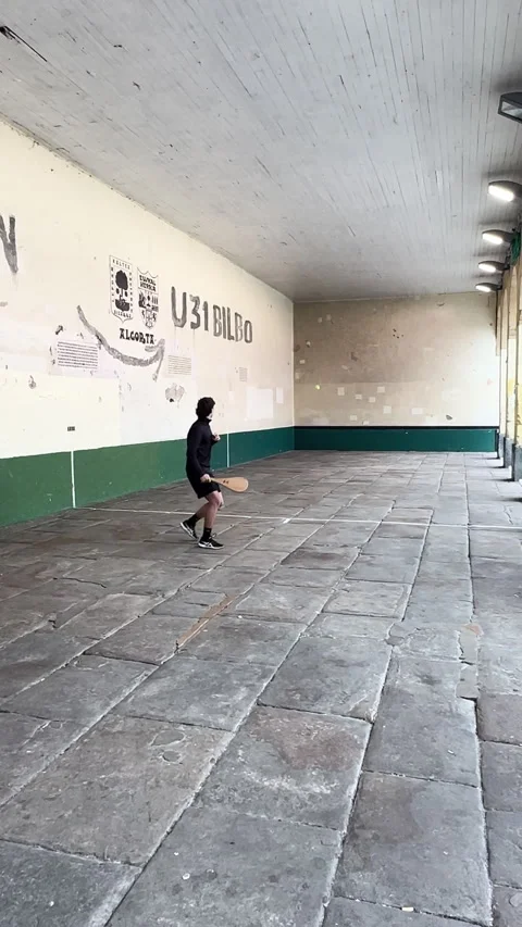 Young man training alone in a fronton, hitting a ball  against a wall Stock Footage 337225325