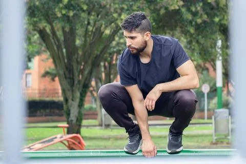 Young man training and doing parkour in a city park Stock Photos
