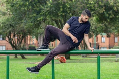 Young man training and doing parkour in a city park Stock Photos