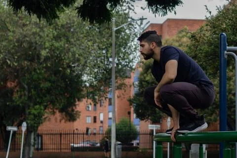 Young man training and doing parkour in a city park Stock Photos