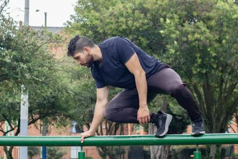 Young man training and doing parkour in a city park Stock Photos