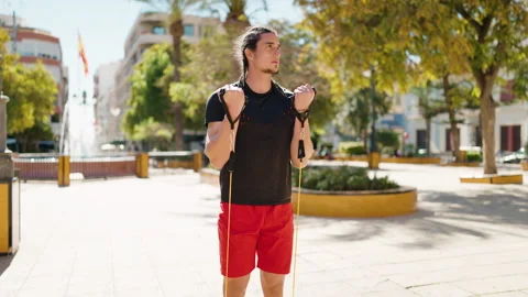 Young man training biceps exercise using elastic band at park Stock Footage 172420189