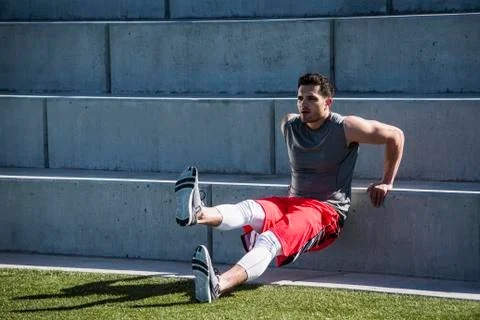 Young man training, doing push up on playing field stairway Fotos Stock