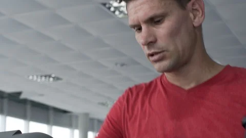 Young Man Training on Elliptical Machine in Gym Stock Footage 99865013