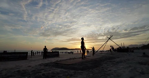 Young man training before fire show at Cenang beach on sunset, slow motion Stock Footage 315205890
