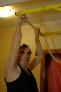 Young Man Training on Gymnastic Wall Bars and Pull-Up Bar at Home Stock Photos