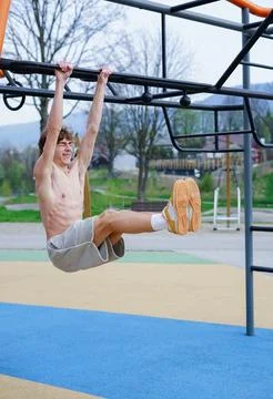 Young man training on outdoor monkey bars Stock Photos