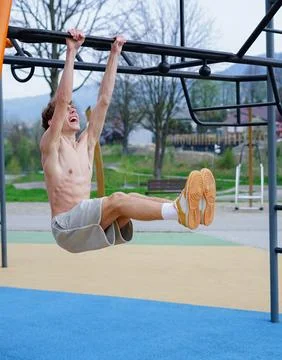 Young man training on outdoor monkey bars Stock Photos