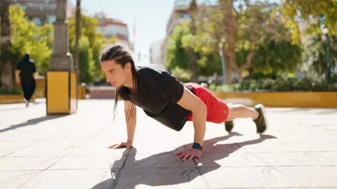 Young man training push ups at park Stock Footage 172071081