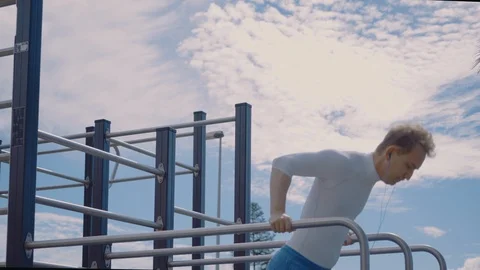 Young man Training in Street Workout Ground and Doing Pull Ups on Bars. Sports Stock Footage 104526098