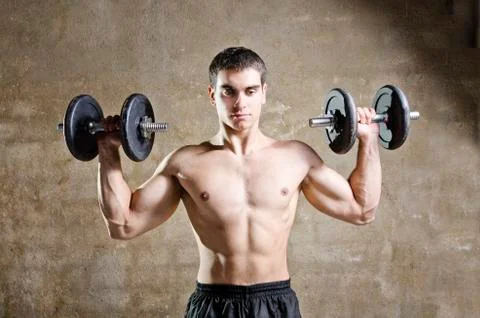 Young man training weights in old gym Stock Photos