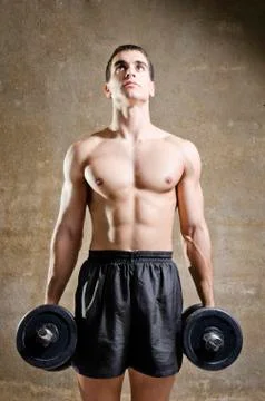 Young man training weights in old gym Stock Photos
