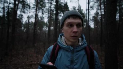 A young man traverses a shadowy forest, seeking adventure or escape Stock Footage 303600882