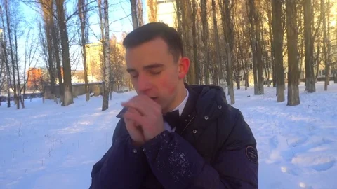 A young man tries to keep warm in winter, standing in the snow Stock Footage 85072556