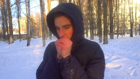 A young man tries to keep warm in winter, standing in the snow 스톡 동영상 85073860