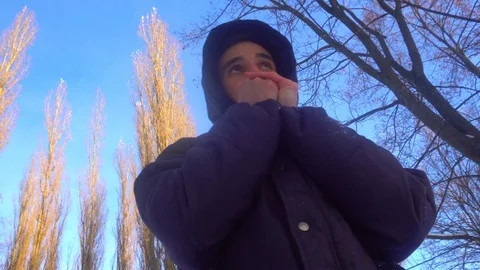 A young man tries to keep warm in winter, standing in the snow Stock Footage 85074275