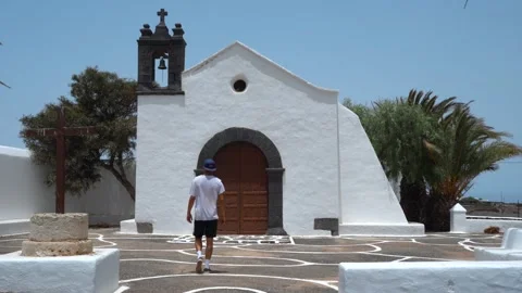 Young man tries to open the door of a lonely little church Stock Footage 136825009