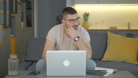 A Young Man Tries To Work From Home, But Fails And He Is Bored Video stock 128366299