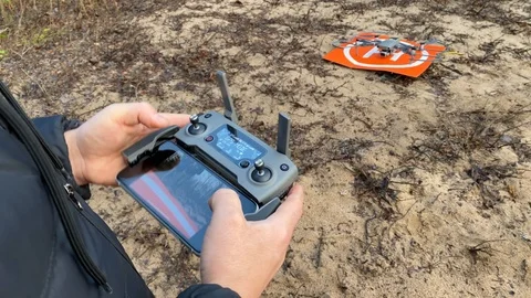 Young man is trying to control a drone through a remote control Video stock 122910863