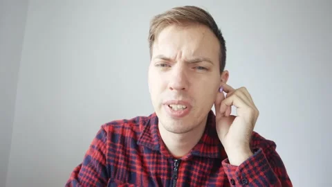 The young man is trying to hear the voice in the headphones Stockbeeldmateriaal 232406102