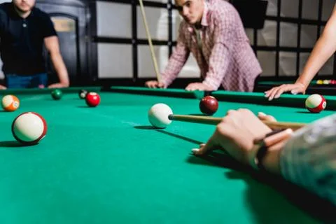 Young man trying to hit the ball in billiard. Stock Illustration