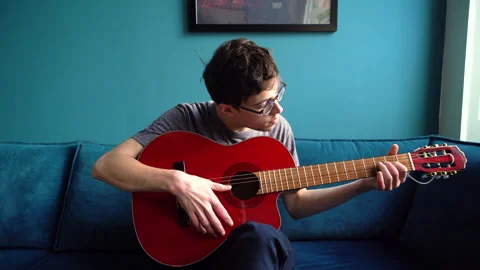 Young Man Trying to Learn Guitar Stock Footage 274174814