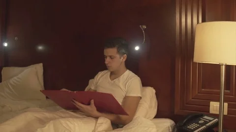 Young man trying to relax reading magazine Stock Footage 73984011