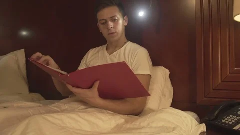 Young man trying to relax reading magazine Stock Footage 73984058