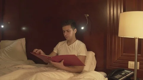 Young man trying to relax reading magazine Stock Footage 73984077