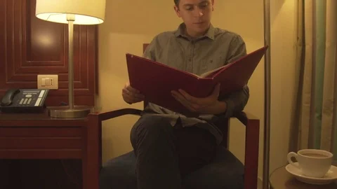 Young man trying to relax reading magazine Stock Footage 73997938