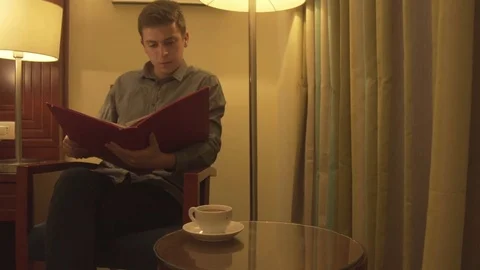 Young man trying to relax reading magazine Stock Footage 73997990