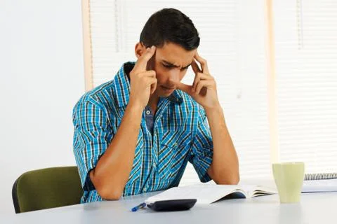 Young man trying to study Stock Photos