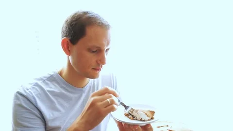 Young man trying, tasting and eating portion piece of tiramisu cake on plate Stock Footage 80206170