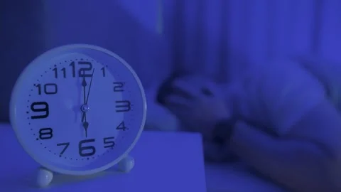 Young man trying to turn off a ringing alarm clock at morning. Close-up of .. Stock Footage 309939494
