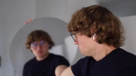 Young man turns toward the mirror and screams in panic as his reflection mirrors Stock Footage 312981896