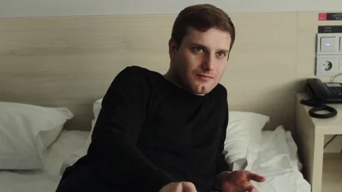 Young man with TV remote watching tv on bed Stock Footage 73450323