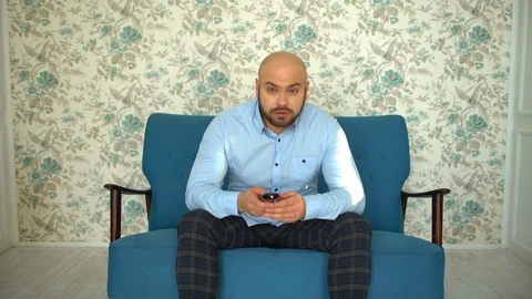Young man with tv remote watching tv on sofa. Stock Footage 86702202