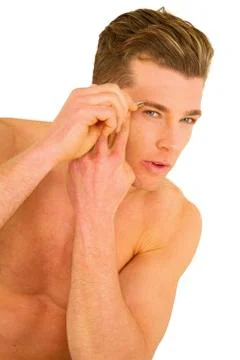 Young man tweezing eyebrows Stock Photos