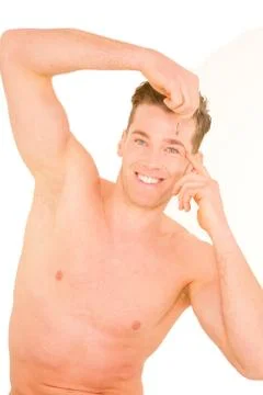 Young man tweezing eyebrows Stock Photos