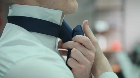 A young man tying a tie on a white shirt Video stock 328299533