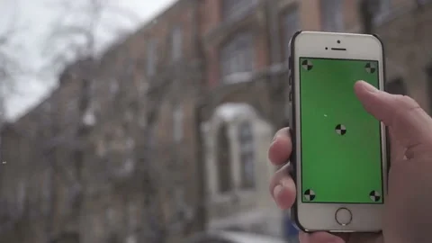 Young man types and slides on his smartphone in the winter street.Chromakey Stock Footage 85595644