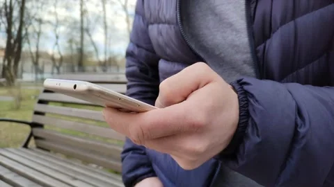 Young man types a text message or downloads an application for his smartphone Vidéo 196486087